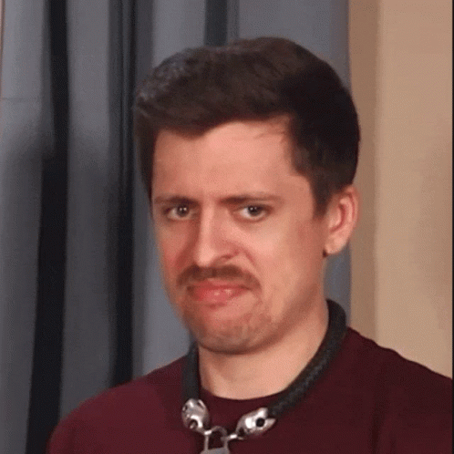 A Man With A Mustache Is Wearing A Necklace With Bells On It . GIF