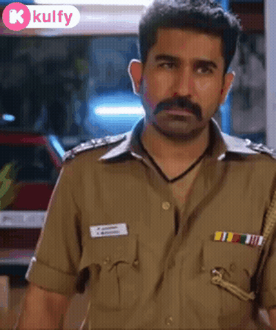 A Man With A Mustache Is Wearing A Police Uniform And Looking At The Camera GIF