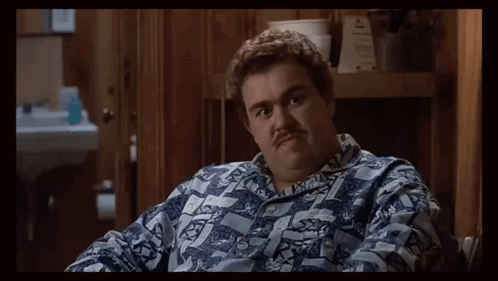 A Man With A Mustache Is Wearing A Shirt That Says ' A ' On The Front GIF