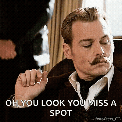 A Man With A Mustache Is Wearing A Suit And Tie And Says Oh You Look You Miss A Spot . GIF