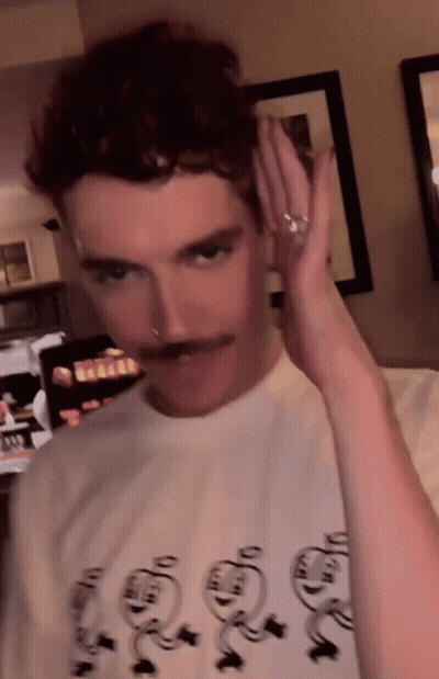 A Man With A Mustache Is Wearing A T-Shirt That Says ' Snoopy ' On The Front GIF