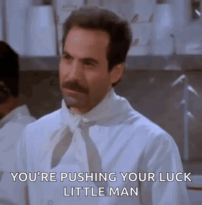 A Man With A Mustache Is Wearing A White Shirt And Tie And Is Pushing His Luck Little Man . GIF