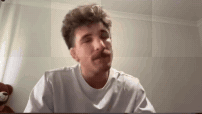 A Man With A Mustache Is Wearing A White T-Shirt And Making A Funny Face . GIF