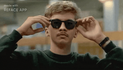 A Man With A Mustache Is Wearing Sunglasses And A Black Sweater . GIF