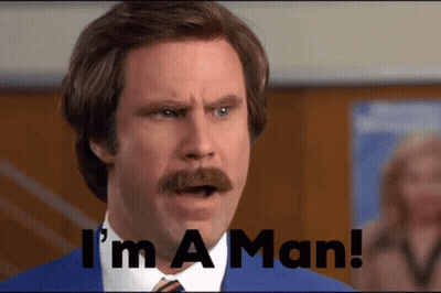A Man With A Mustache Says " I 'M A Man " In Front Of Him GIF