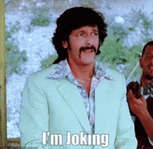 A Man With A Mustache Says I 'M Joking In A Green Suit GIF