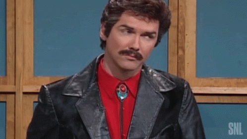 A Man With A Mustache Wearing A Black Leather Jacket And A Red Shirt Is Giving A Thumbs Up . GIF