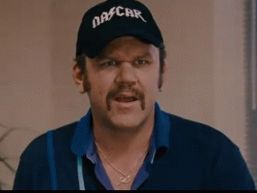 A Man With A Mustache Wearing A Nascar Hat And A Blue Shirt Is Making A Funny Face . GIF