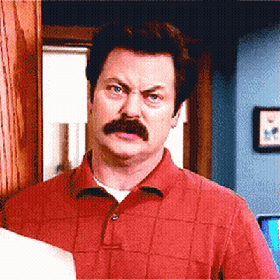 A Man With A Mustache Wearing A Red Shirt Looks At The Camera GIF