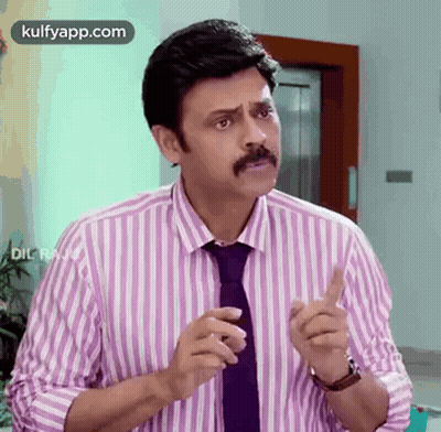 A Man With A Mustache Wearing A Striped Shirt And Tie Is Making A Funny Face . GIF