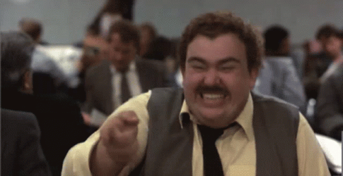 A Man With A Mustache Wearing A Vest And Tie Is Making A Funny Face GIF