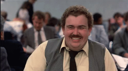 A Man With A Mustache Wearing A Vest And Tie Is Smiling GIF