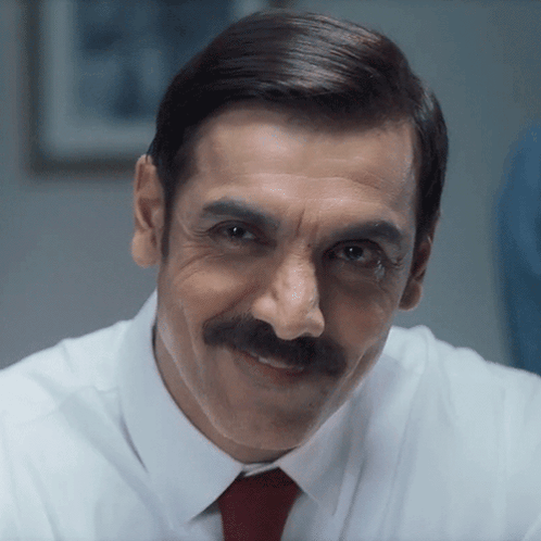 A Man With A Mustache Wearing A White Shirt And A Red Tie GIF