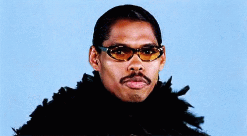 A Man With A Mustache Wearing Sunglasses And A Feather Boa . GIF