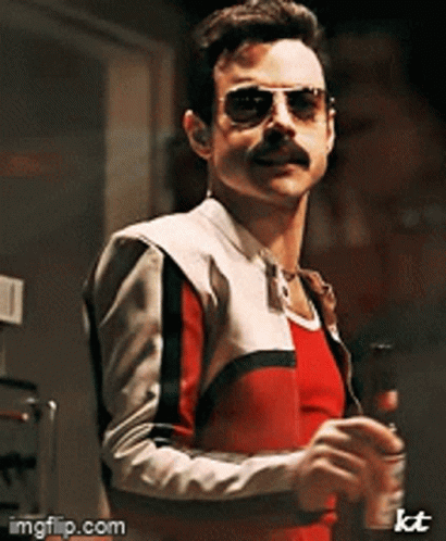 A Man With A Mustache Wearing Sunglasses And A Red And White Jacket GIF
