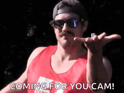 A Man With A Mustache Wearing Sunglasses And A Red Tank Top Says " Coming For You Cam " GIF