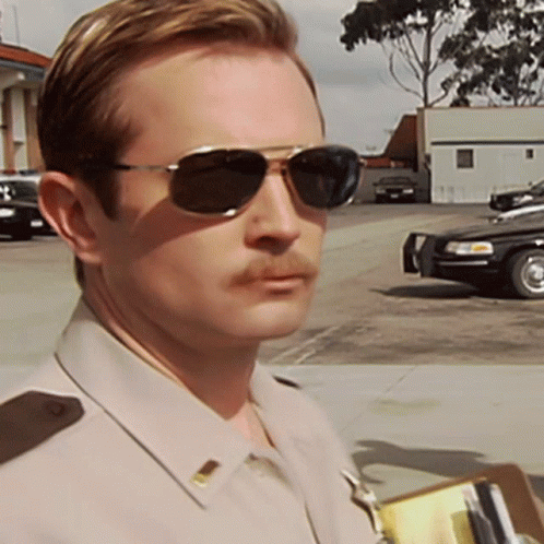 A Man With A Mustache Wearing Sunglasses And A Uniform GIF