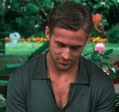 A Man With A Necklace Around His Neck Looks Down At Something GIF