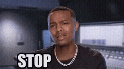 A Man With A Necklace Is Making A Stop Sign . GIF