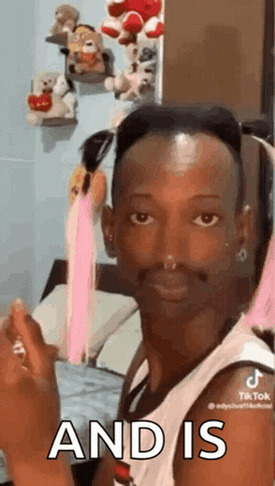 A Man With A Nose Ring Is Sitting On A Bed And Making A Face . GIF