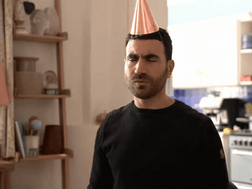 A Man With A Party Hat On His Head GIF