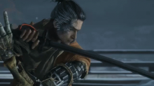 A Man With A Ponytail Is Holding A Sword In His Right Hand GIF