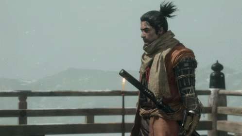 A Man With A Ponytail Is Holding A Sword In His Right Hand GIF