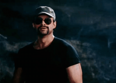 A Man With A Ponytail Wearing Sunglasses And A Hat GIF