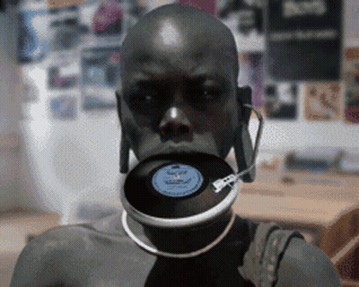 A Man With A Record In His Mouth And Headphones GIF