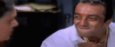 A Man With A Red Dot On His Forehead Is Smiling While Talking To Another Man . GIF
