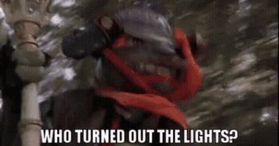 A Man With A Red Scarf Around His Neck Is Holding A Cane And Asking Who Turned Out The Lights . GIF