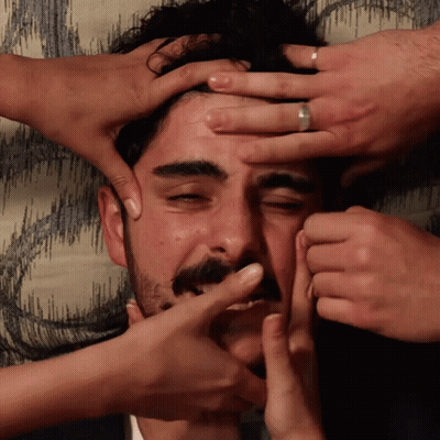 A Man With A Ring On His Finger Is Being Squeezed By Several People GIF