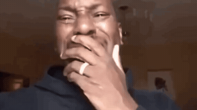 A Man With A Ring On His Finger Is Covering His Mouth With His Hands . GIF