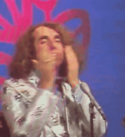 A Man With A Ring On His Finger Is Covering His Mouth With His Hands GIF