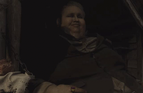 A Man With A Ring On His Finger Is Laughing In A Dark Room GIF
