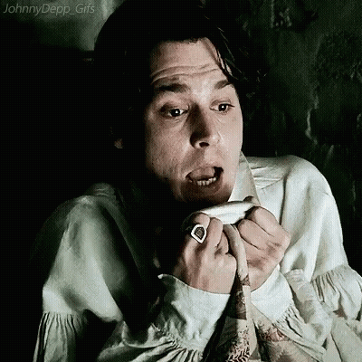 A Man With A Ring On His Finger Is Making A Funny Face While Sitting In A Chair . GIF
