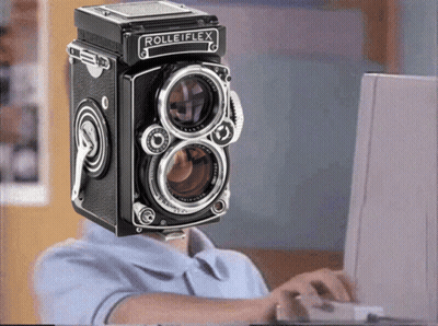 A Man With A Rolleiflex Camera On His Head GIF
