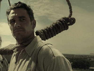A Man With A Rope Around His Neck Is Looking At The Camera GIF