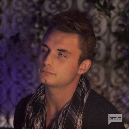 A Man With A Scarf Around His Neck And A Bravo Logo In The Corner GIF