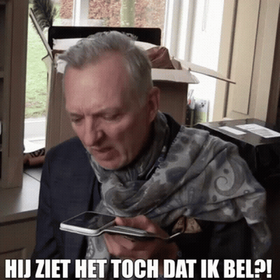 A Man With A Scarf Around His Neck Is Looking At A Cell Phone And The Caption Says Hij Ziet Het Toch Dat Ik Bel GIF