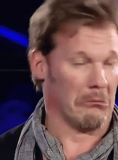 A Man With A Scarf Around His Neck Is Making A Funny Face With His Eyes Closed GIF