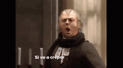 A Man With A Scarf Around His Neck Is Standing In Front Of Candles And Screaming . GIF