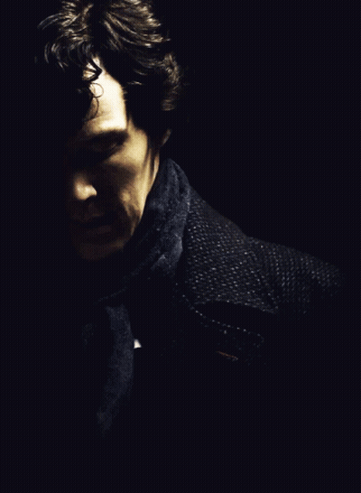 A Man With A Scarf Around His Neck Looks Down GIF