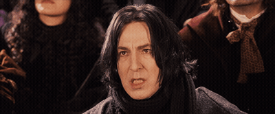 A Man With A Scarf Around His Neck Stands In Front Of A Group Of People GIF