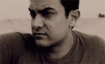 A Man With A Serious Look On His Face Is Wearing A Black Shirt . GIF