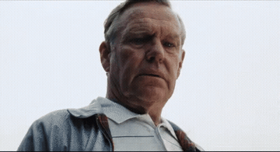 A Man With A Serious Look On His Face Is Wearing A Plaid Shirt GIF