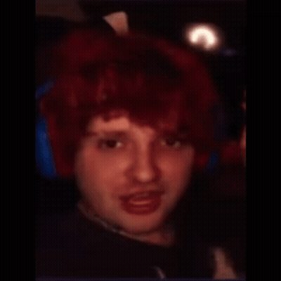 A Man With A Shaved Head And Red Hair Looks At The Camera GIF