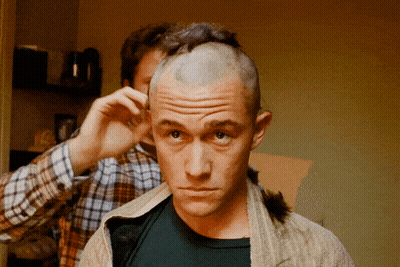 A Man With A Shaved Head Is Getting His Hair Cut By Another Man GIF