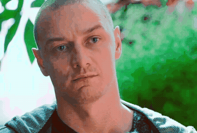 A Man With A Shaved Head Looks At The Camera With A Serious Look On His Face GIF