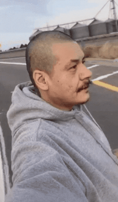 A Man With A Shaved Head Wearing A Grey Sweatshirt GIF